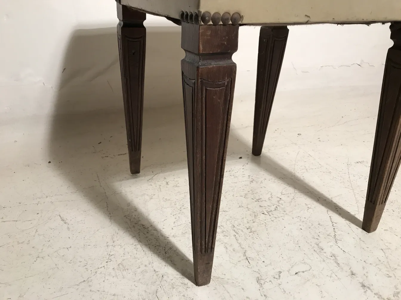 Ancien tabouret avec des pattes tournées décoratives.