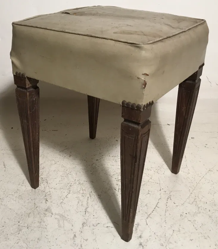 antik hocker mit gepolstertem Sitz in neutralem Umfeld