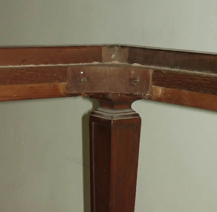 Vista de una antigua banqueta con base y pata elegante.