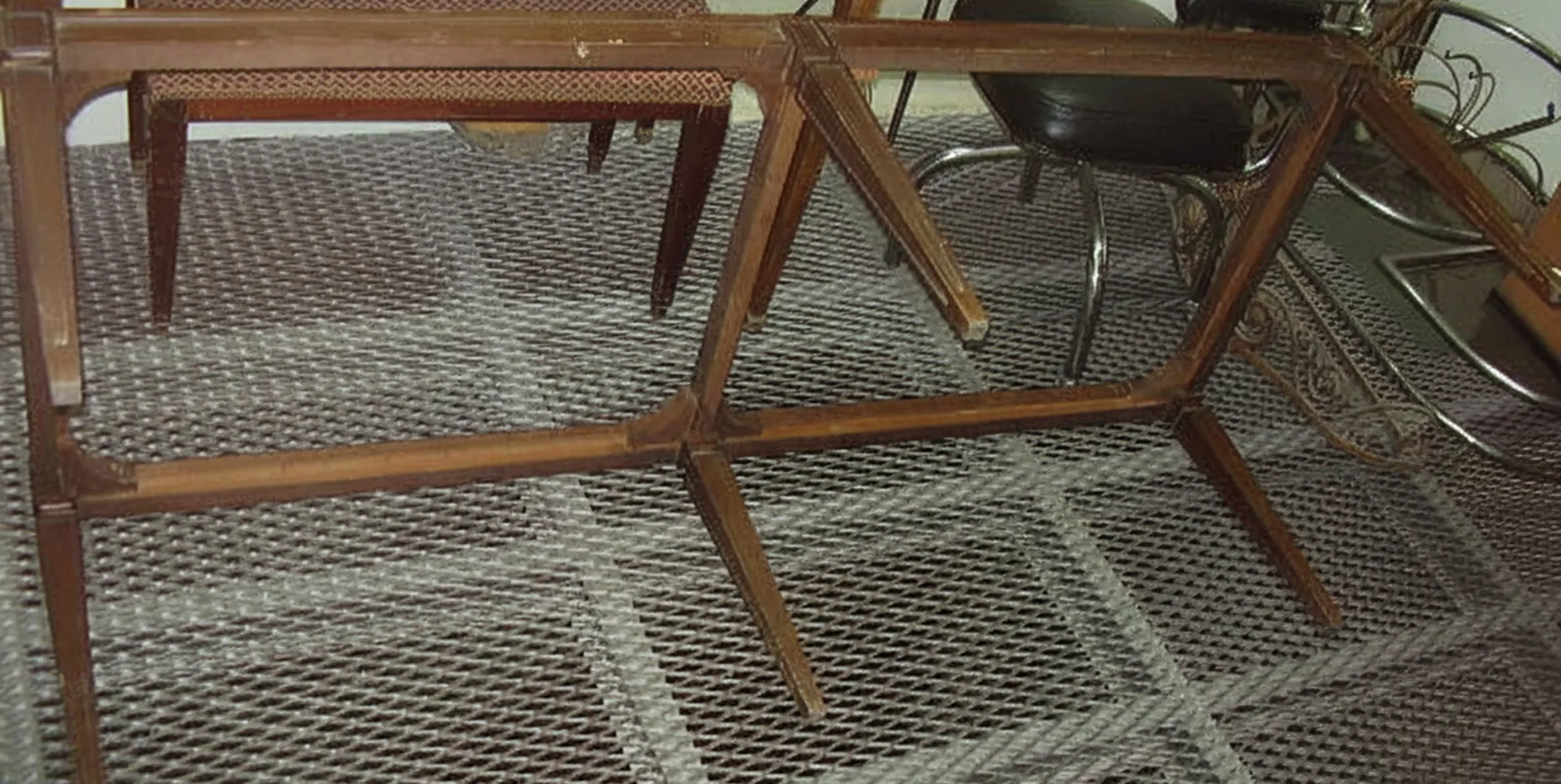 Antiker Hocker in einer klassischen Umgebung mit geneigten Beinen.