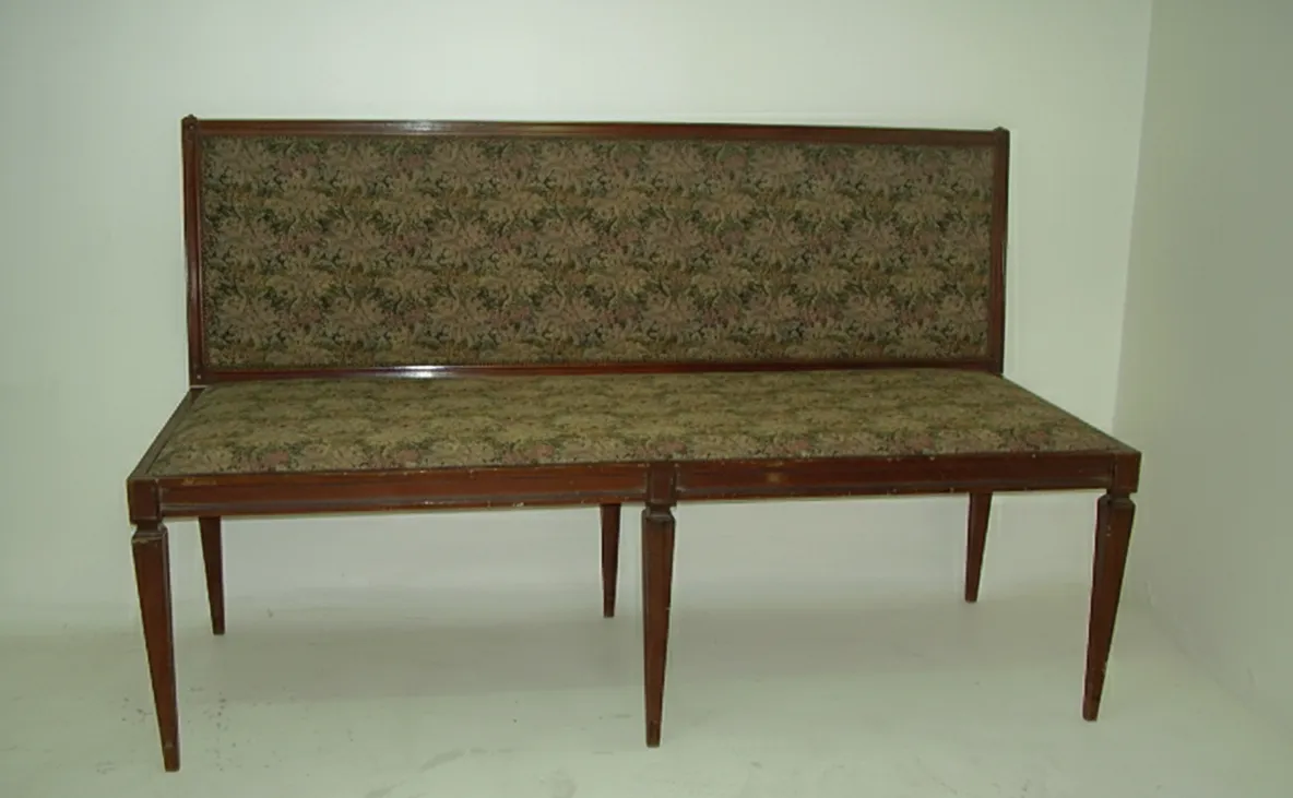 Banqueta antiga com encosto decorado, ideal para ambientes clássicos.