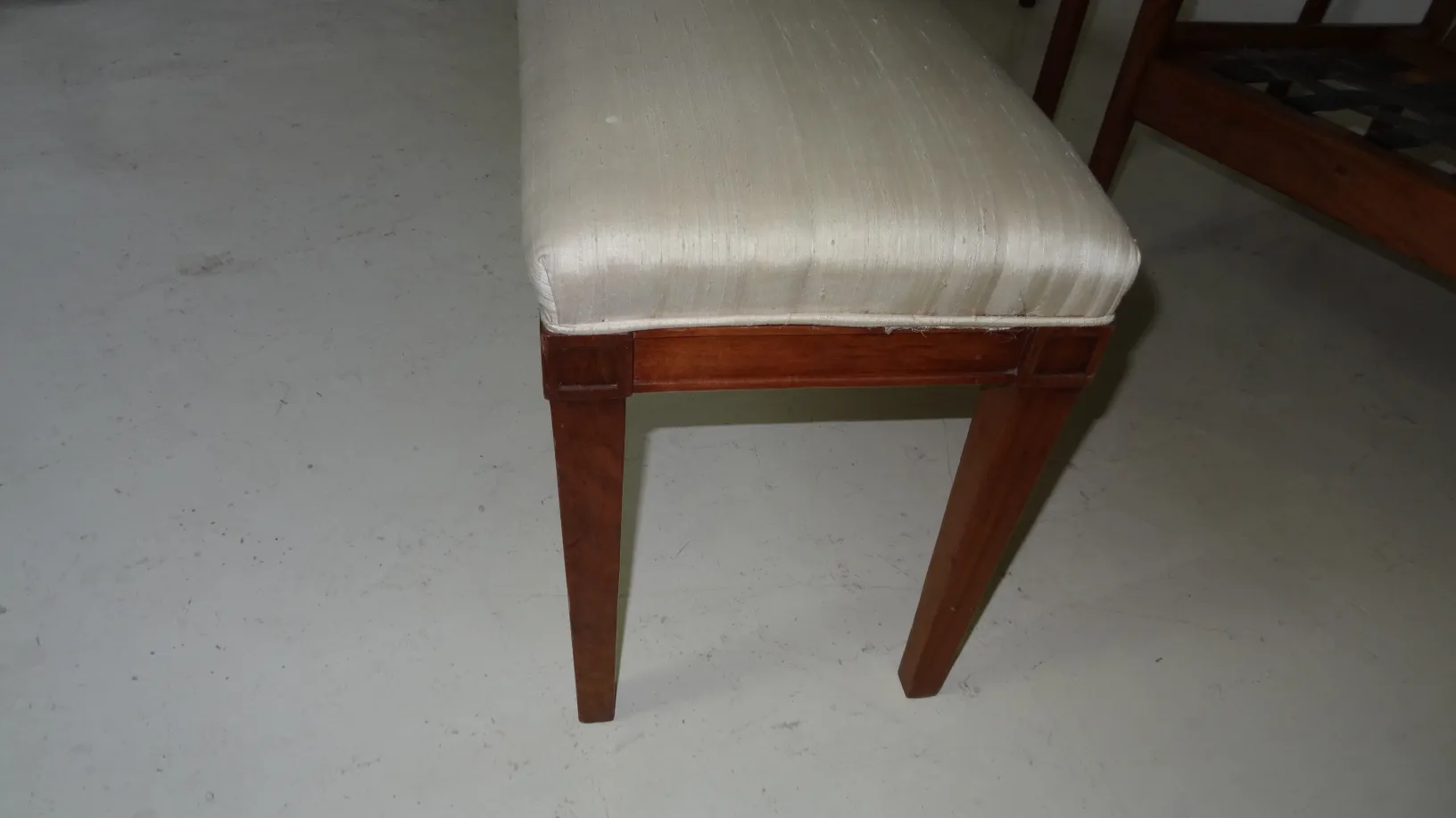 antique stool with light padded seat in room