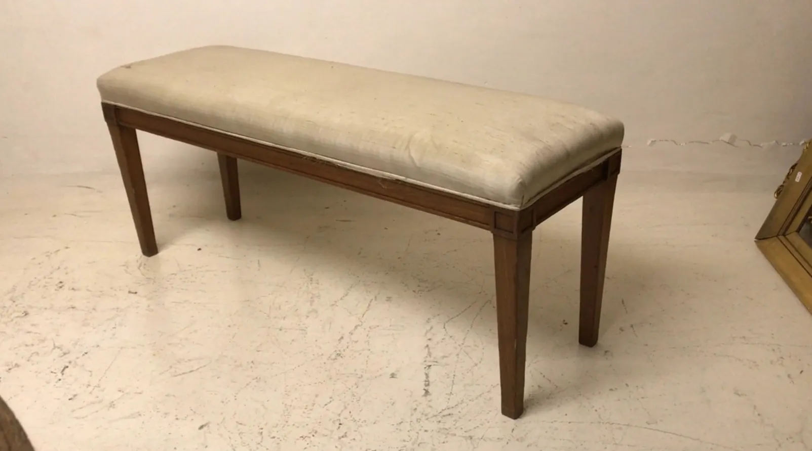 Banqueta antiga com estofamento suave e pernas elegantes