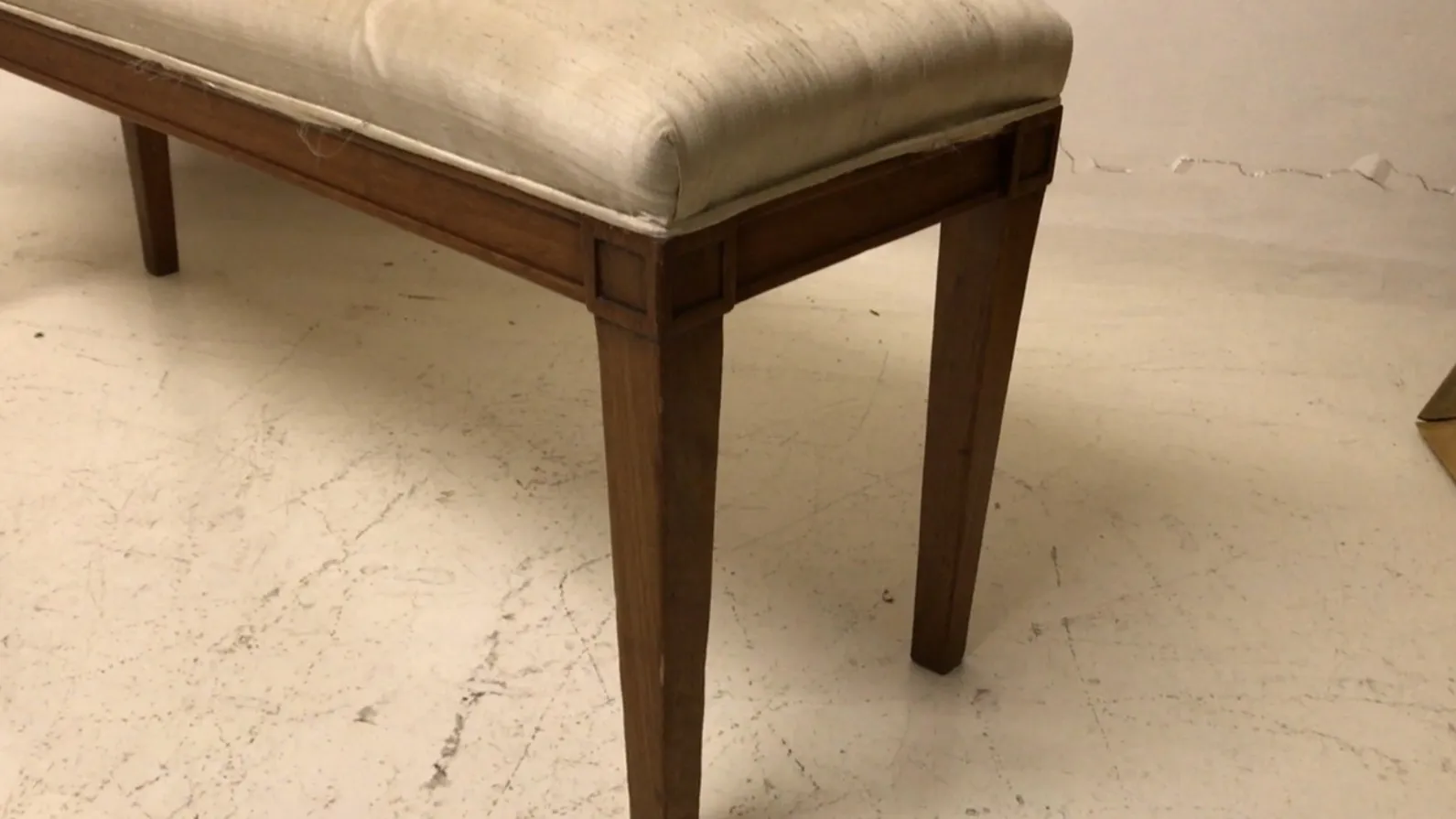 sgabello antico con design semplice e cuscino comodo, in un ambiente neutro