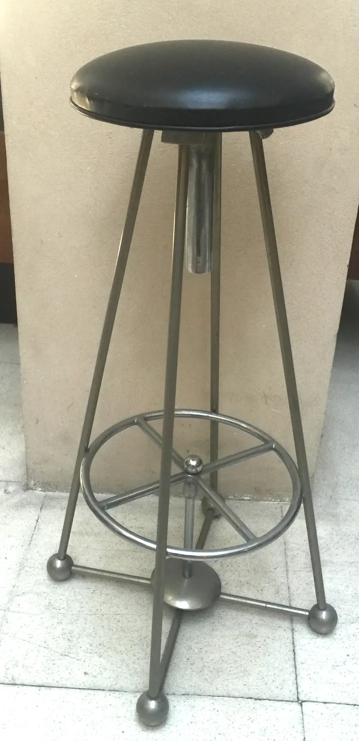 antique stool with metal base and black seat