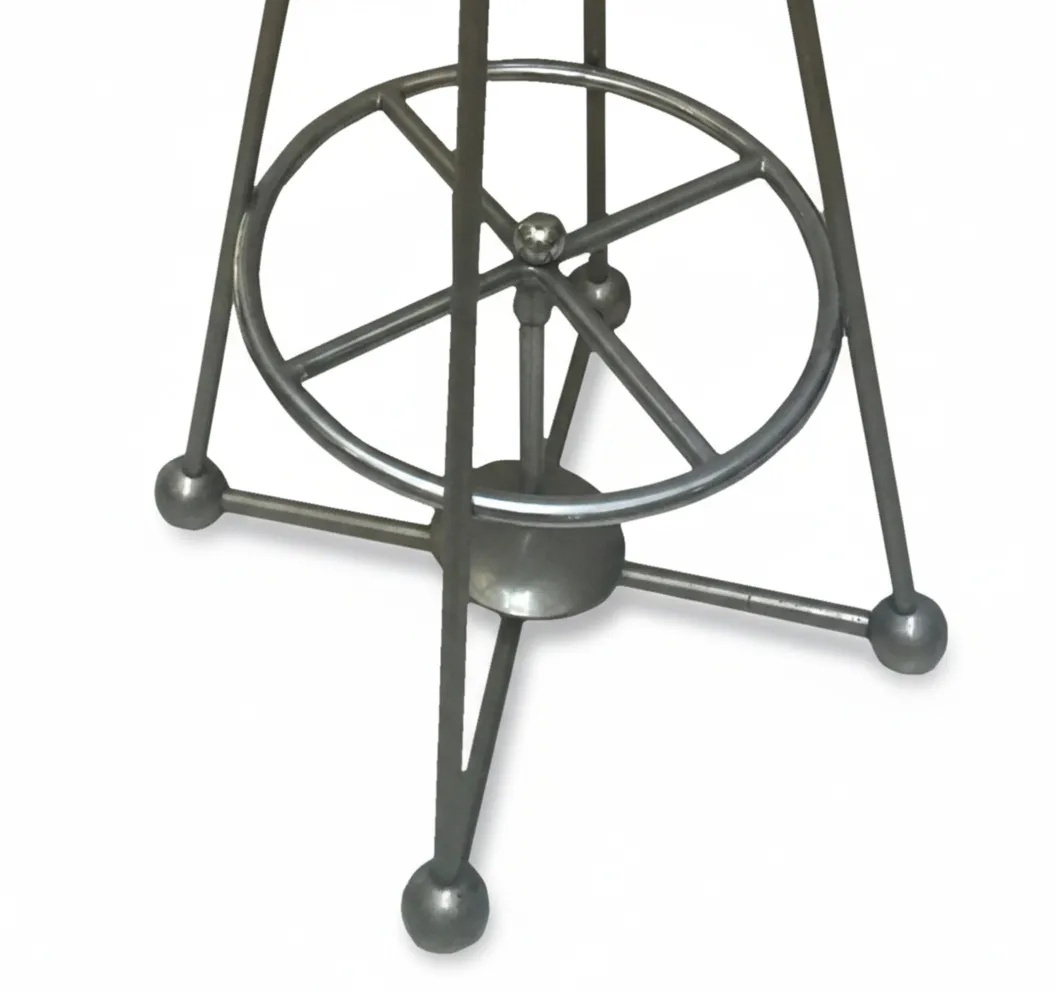 Detail eines antiken Hockers mit dekorativem Metallfuß.