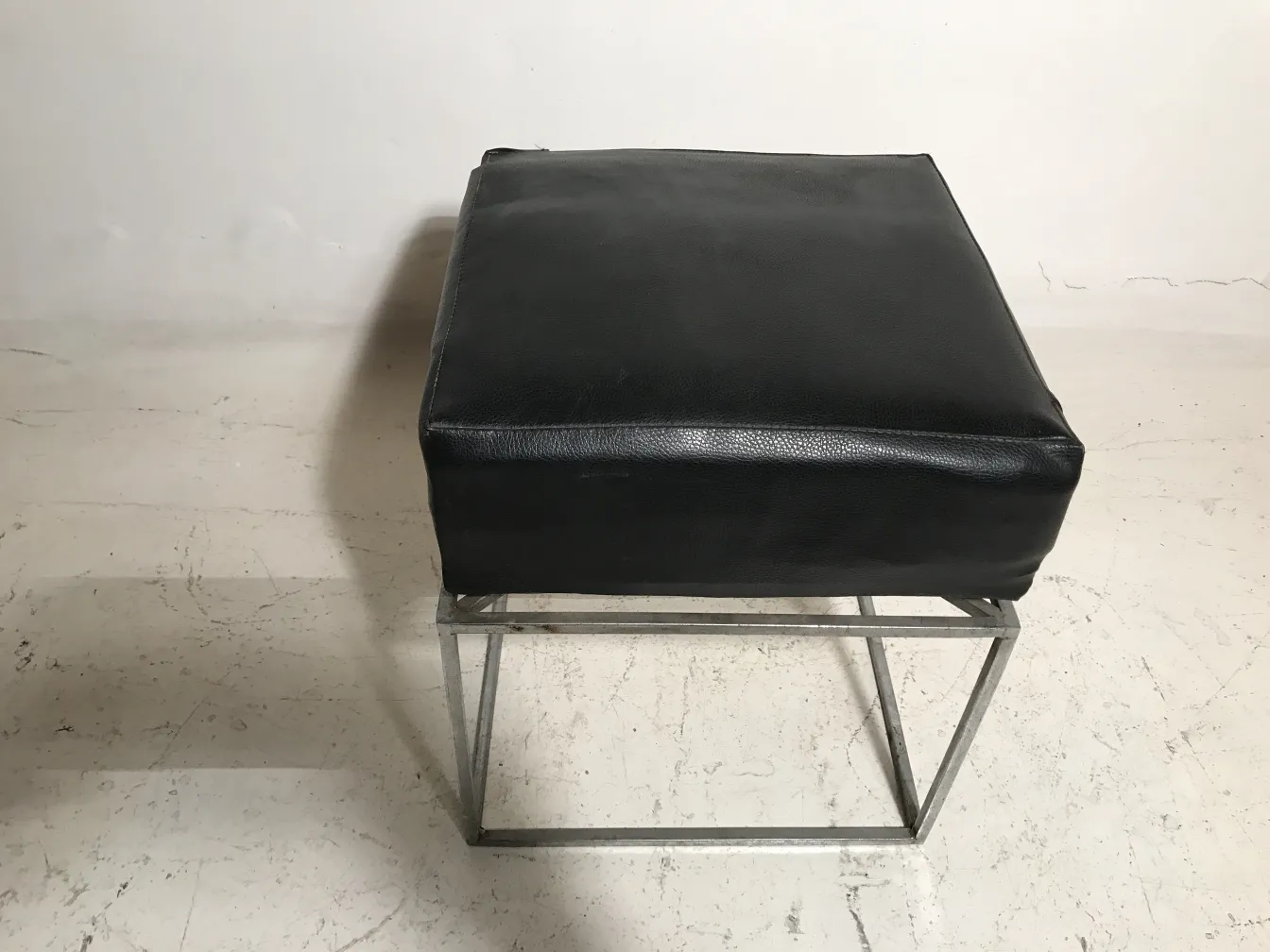tabouret ancien noir avec base en métal, sur fond clair