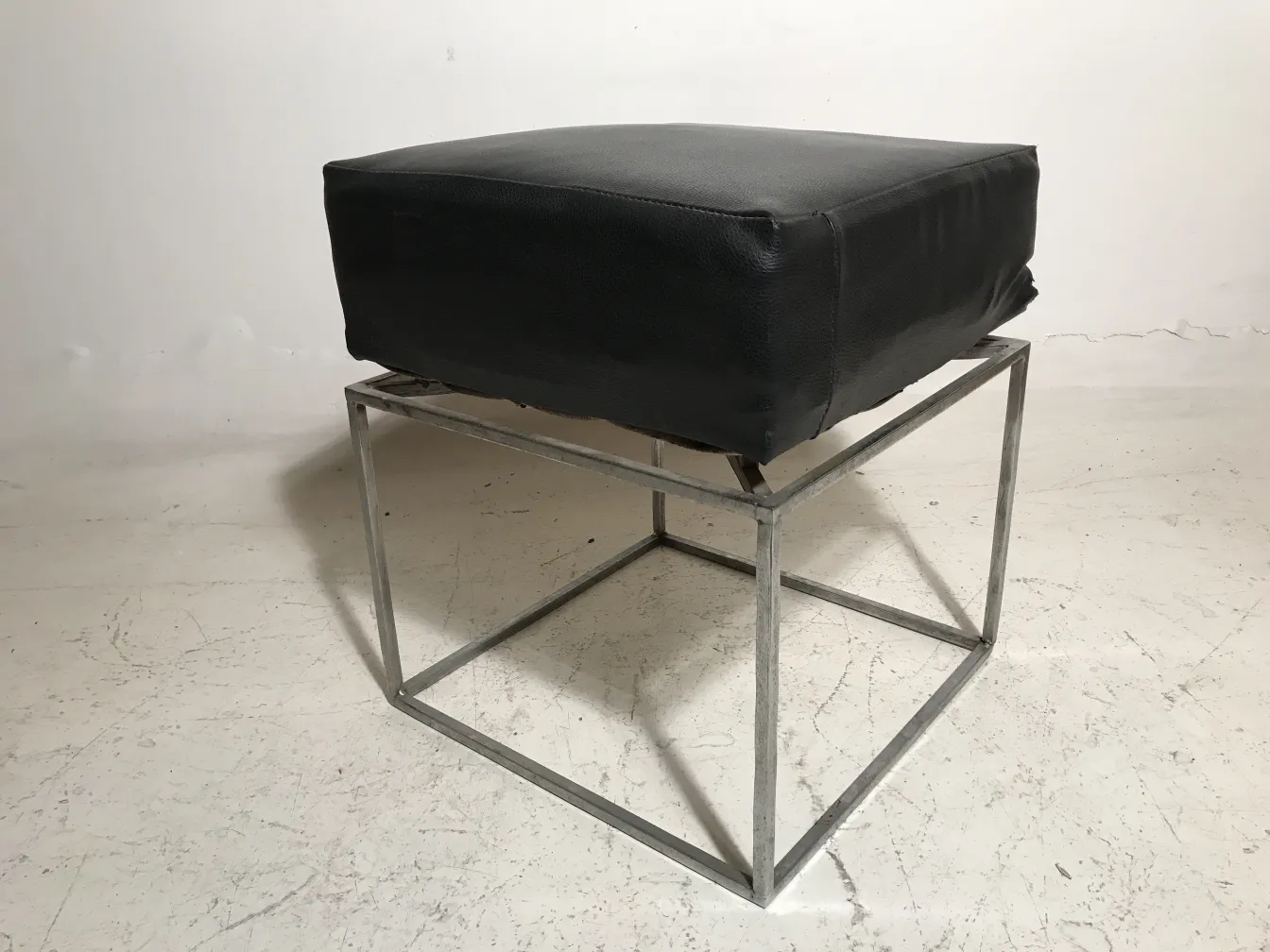 Antique sidewalk with black seat in a neutral setting.