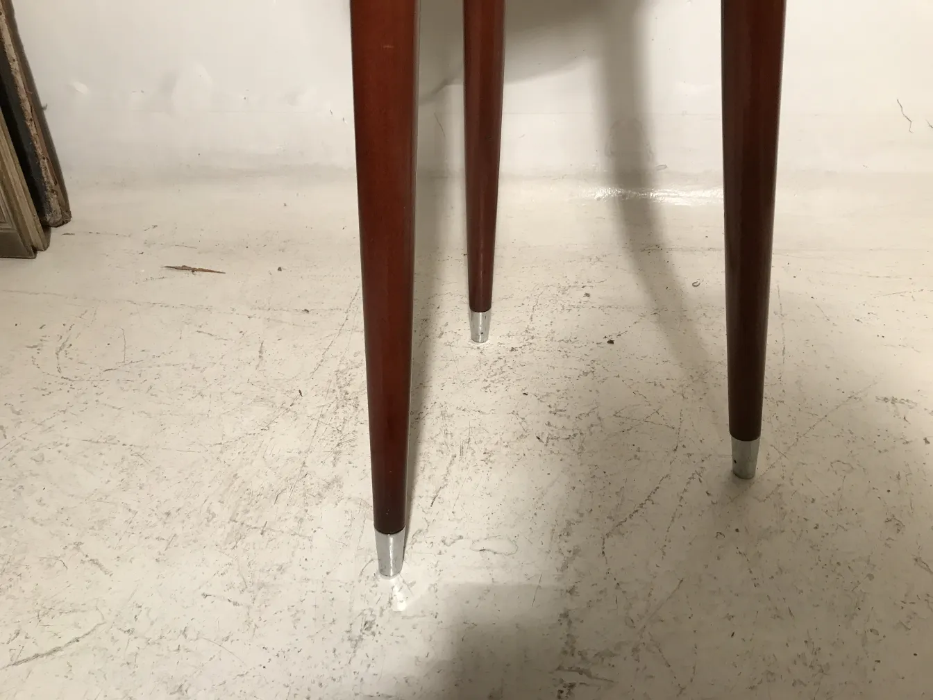 Vue d'un tabouret ancien avec des pattes élégantes dans un cadre vintage.