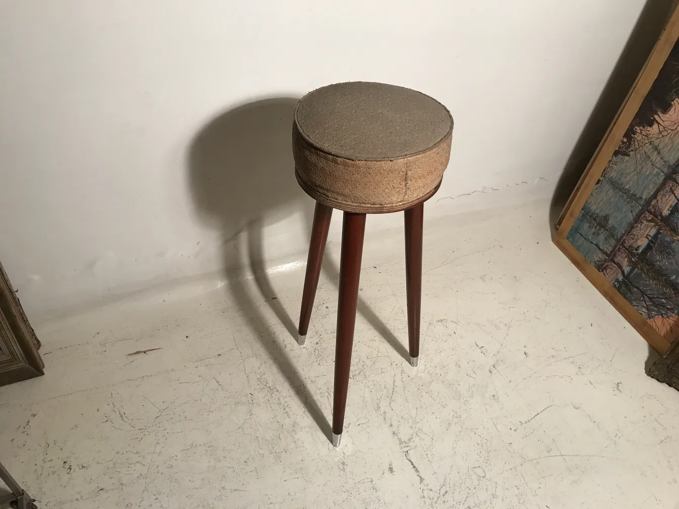 antique three-legged stool in a minimalist setting