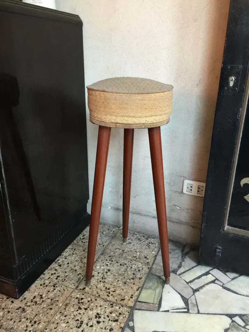 Tabouret ancien à trois pattes, dans un cadre classique et accueillant.