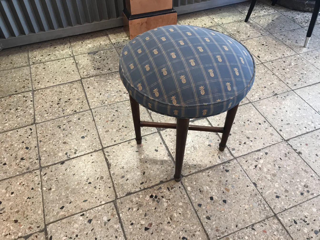antique round stool with pattern, cozy surroundings.