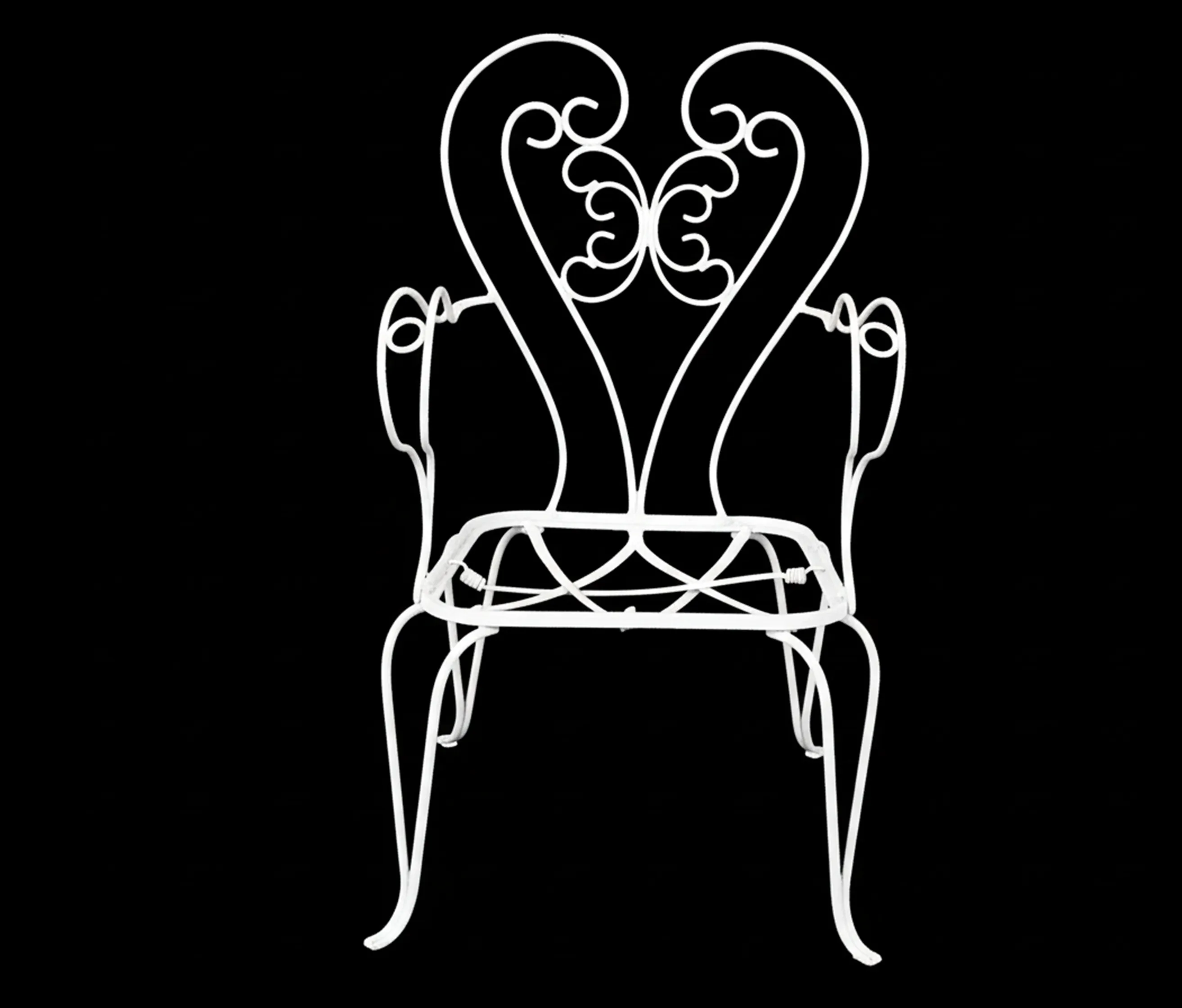 poltronas de jardim antigas de metal branco com detalhes ornamentais em um fundo preto