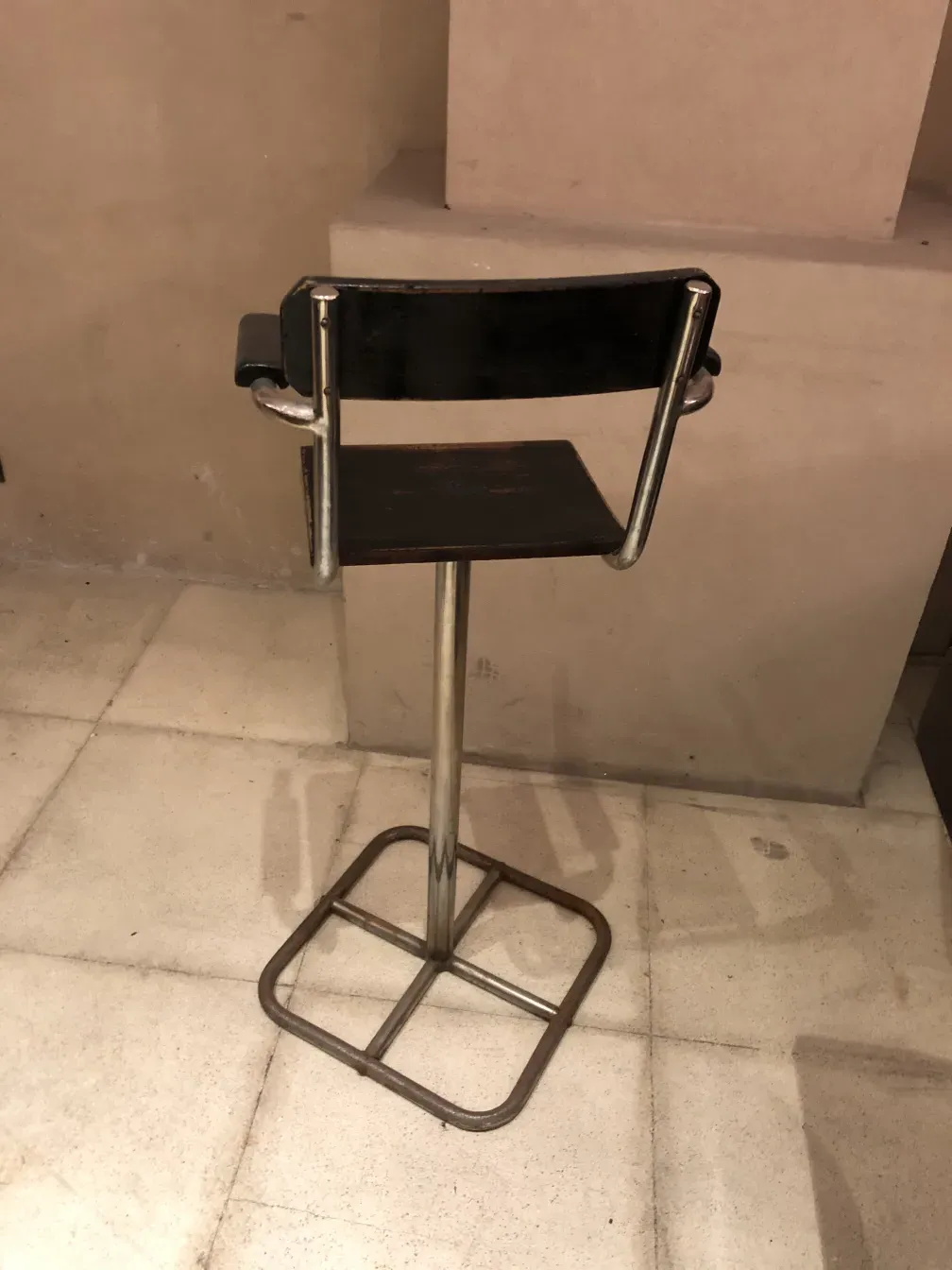 Una silla antigua de diseño Brehuer con base metálica, en un entorno moderno
