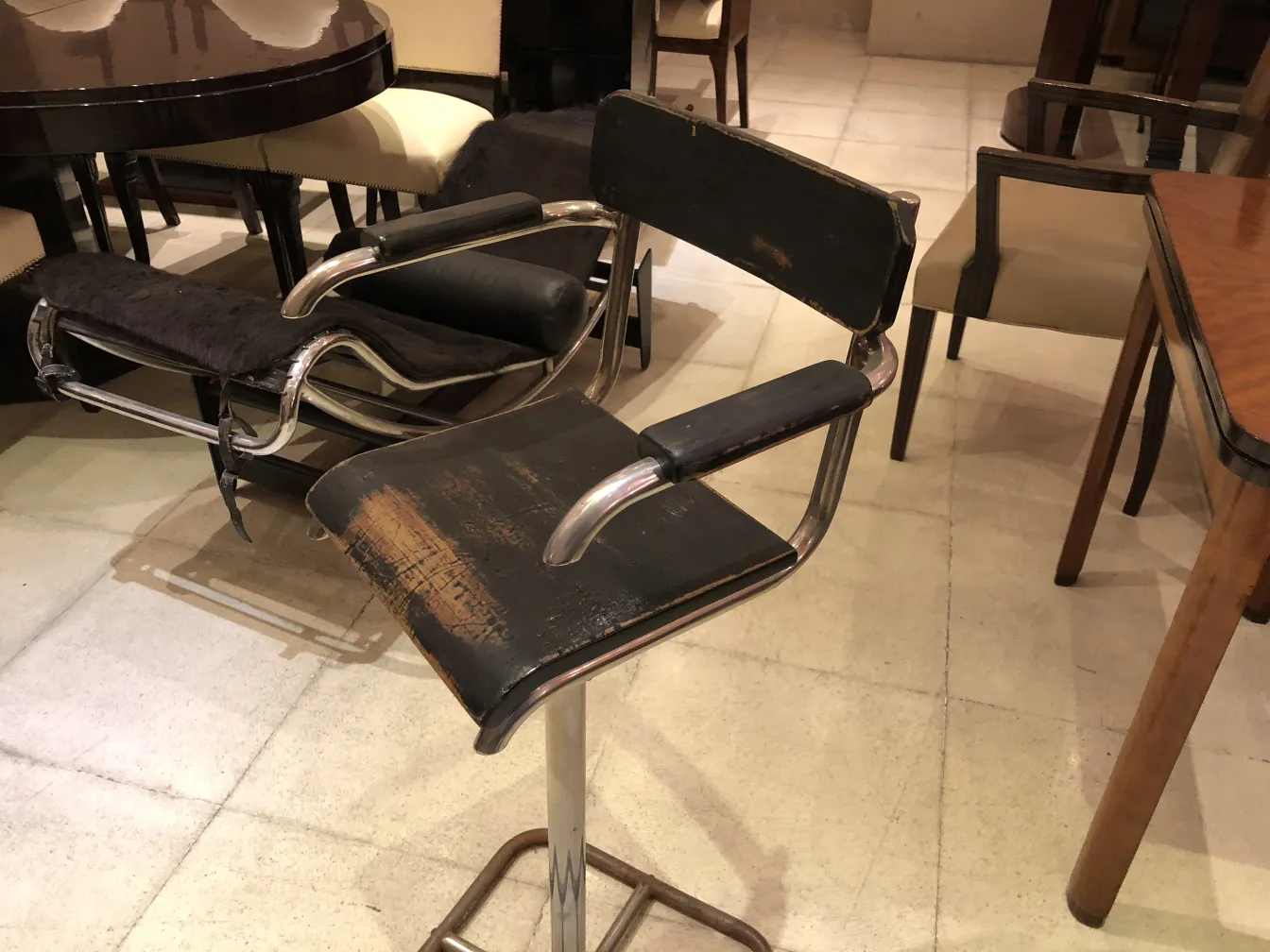 Silla antigua Brehuer con diseño retro, en un ambiente acogedor, ideal para restaurar. Se observan marcas de uso.