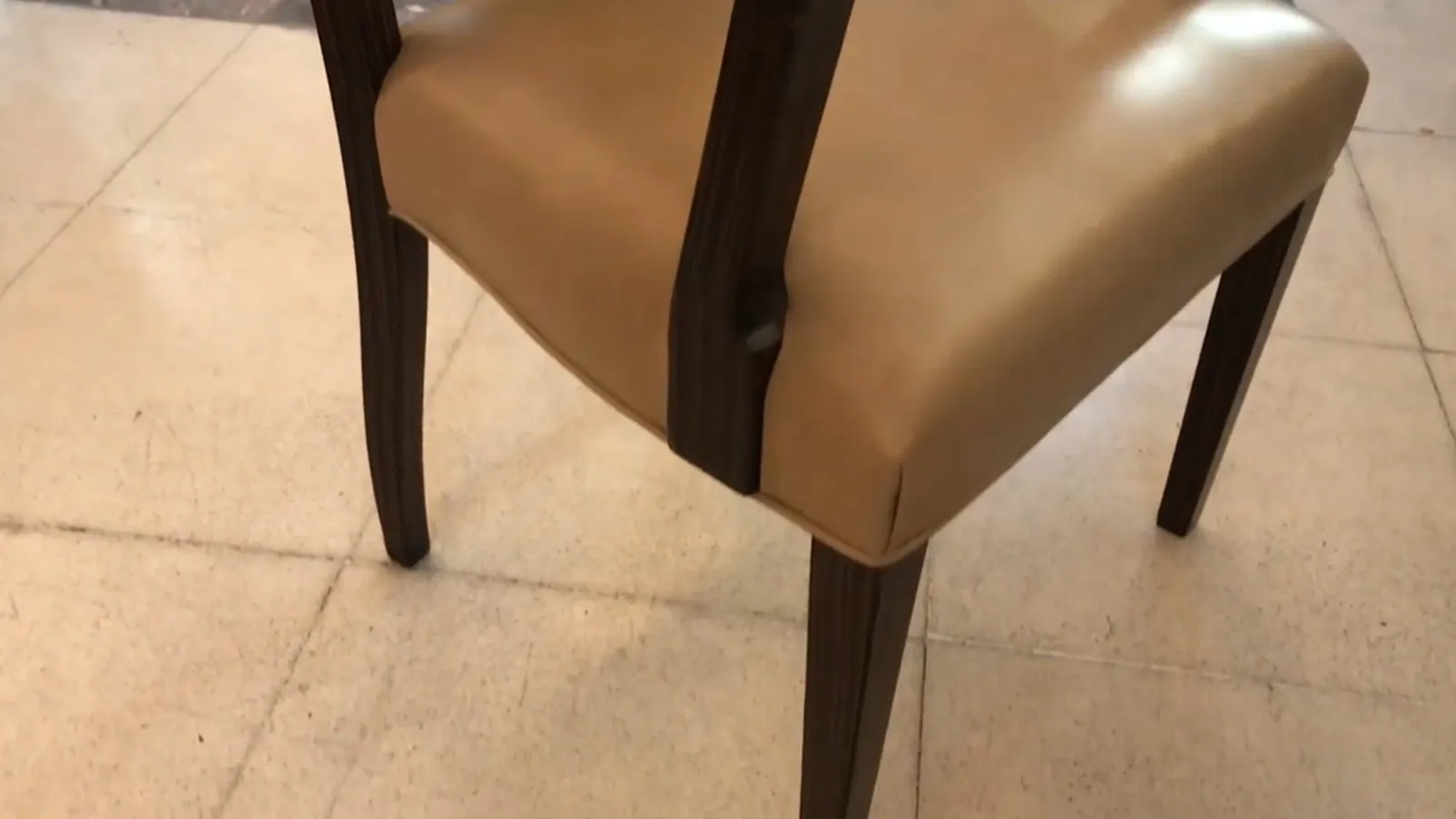 Sillón antiguo Art Deco con reposabrazos en un entorno minimalista.