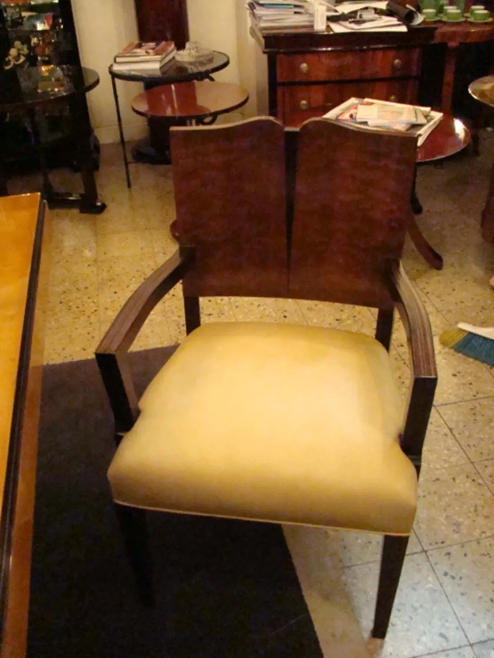 Antique armchair in Art Deco style with arms and light cushion in a stylish setting.