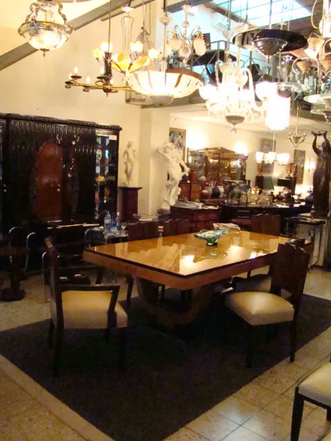 Cuatro sillas antiguas en un entorno decorativo con luces y muebles elegantes.