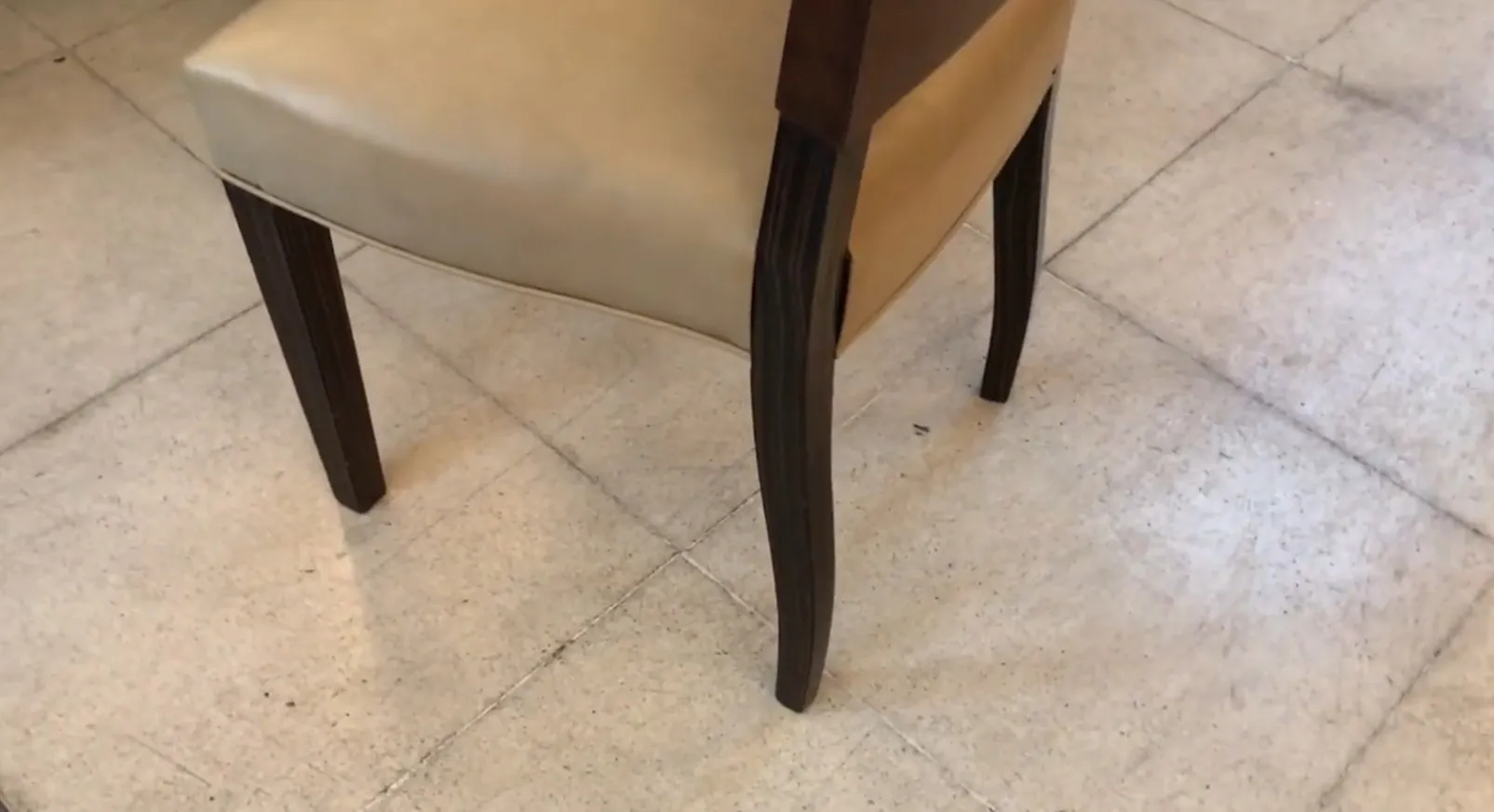 تفاصيل كرسي عتيق بأرجل أنيقة في بيئة بسيطة.