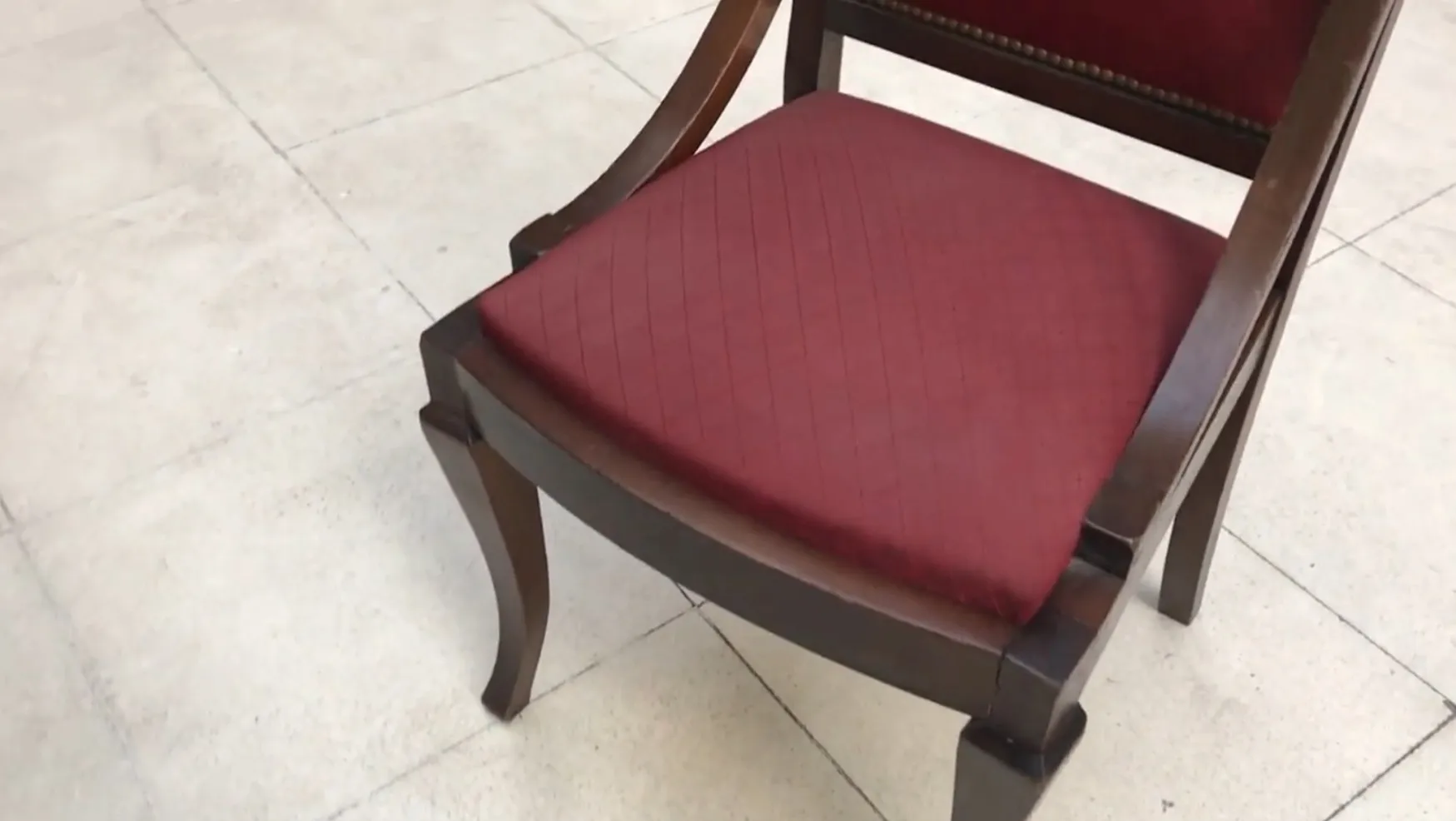 Six antique chairs to restore, with red upholstery, in a neutral setting.