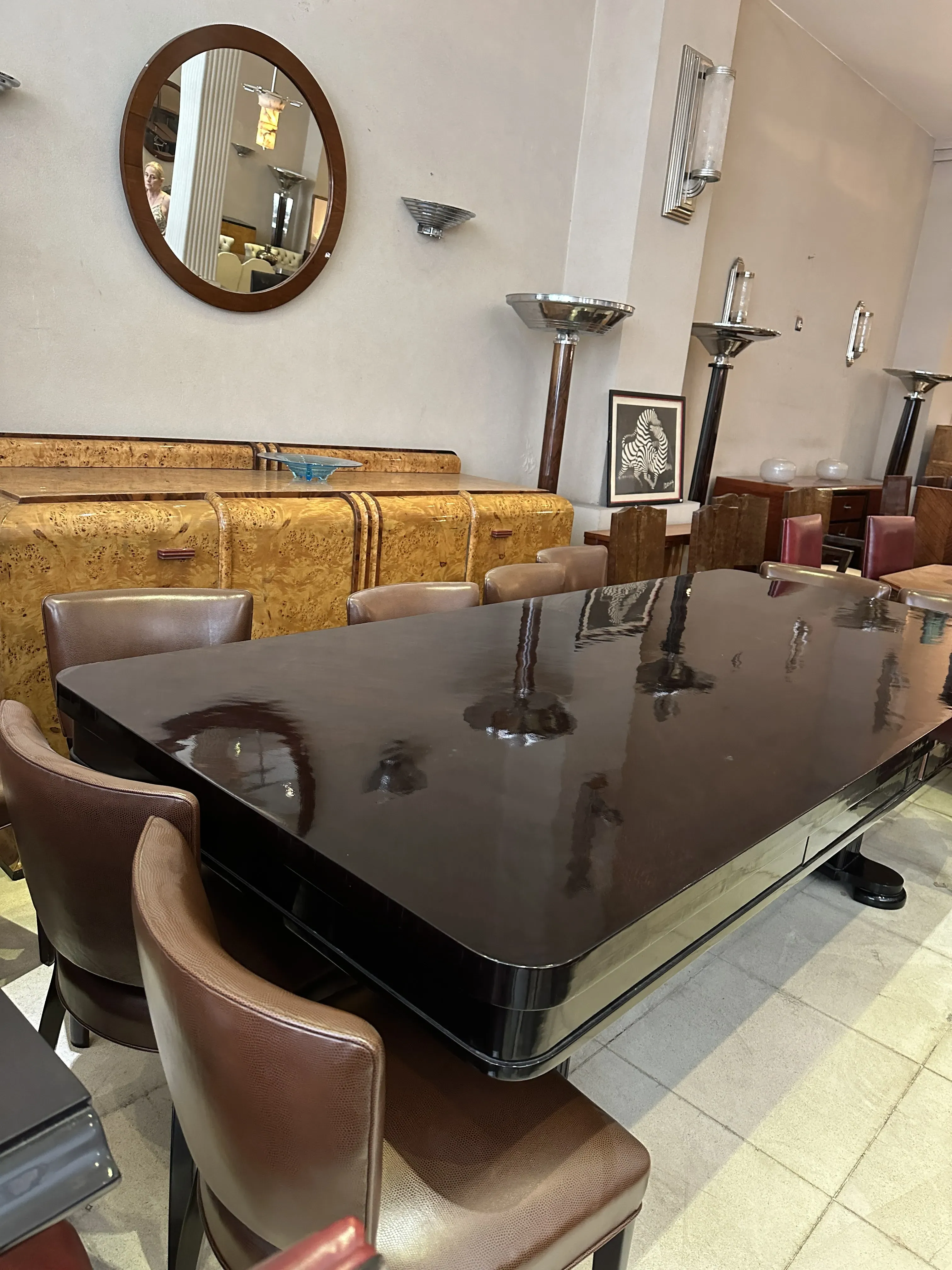 Antique dining table for 10 people with brown chairs.