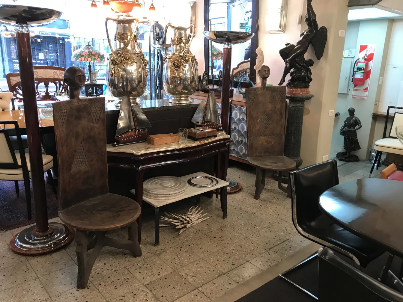 Conjunto de antigüedades con sillas restauradas en ambiente elegante.