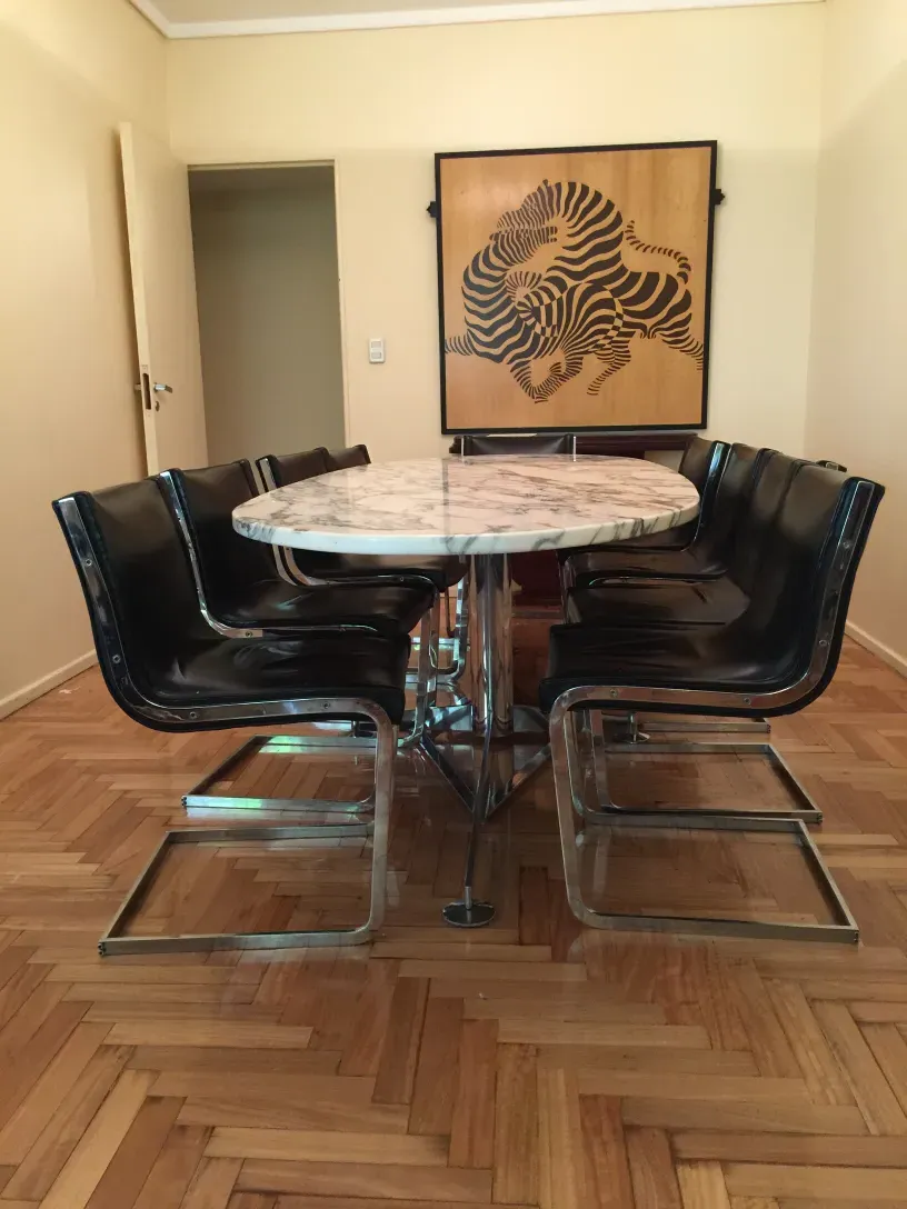 10 chaises anciennes autour d'une table ronde, ambiance chaleureuse