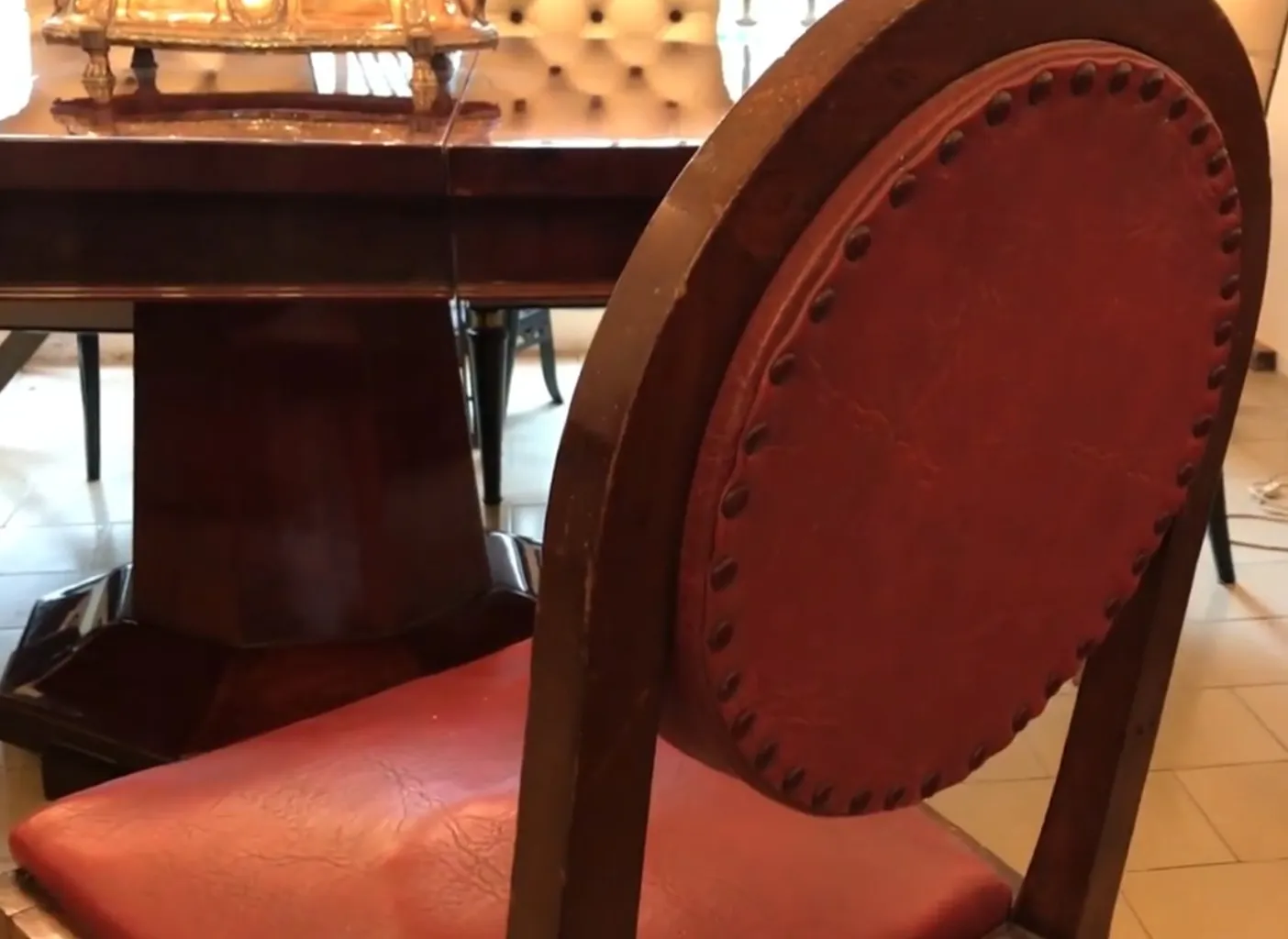 12 كراسي عتيقة ذات تنجيد أحمر في بيئة راقية.