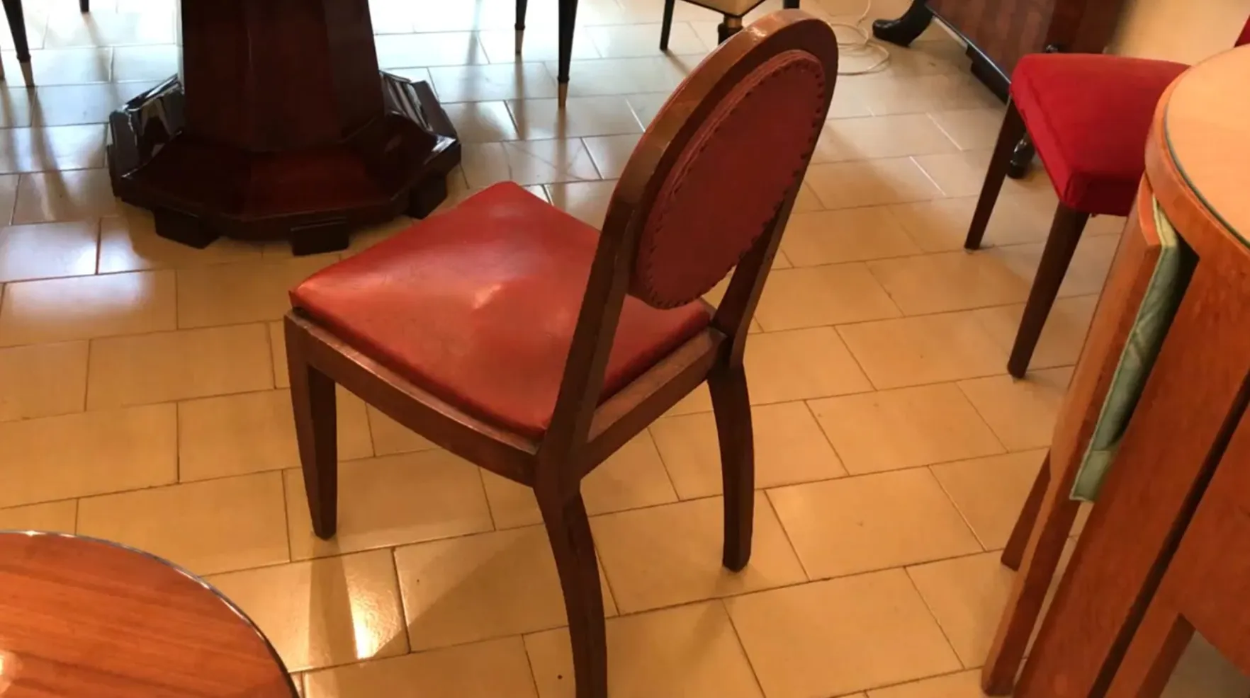 12 sillas con tapizado rojo en un entorno antiguo