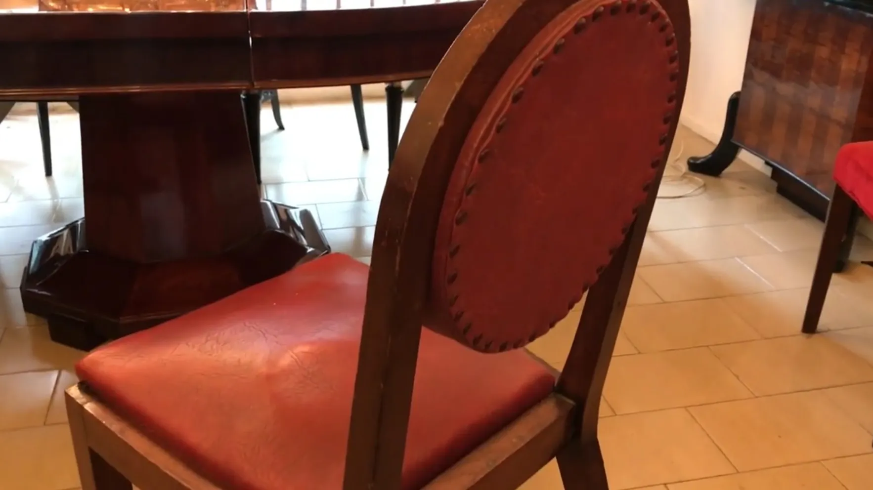 Vista di diverse sedie antiche con rivestimento rosso in un ambiente elegante