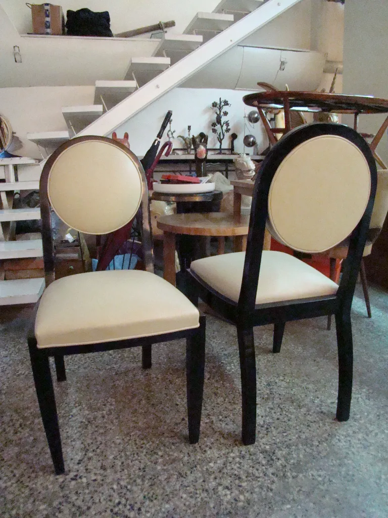 Two antique chairs with round backs in a vintage setting.