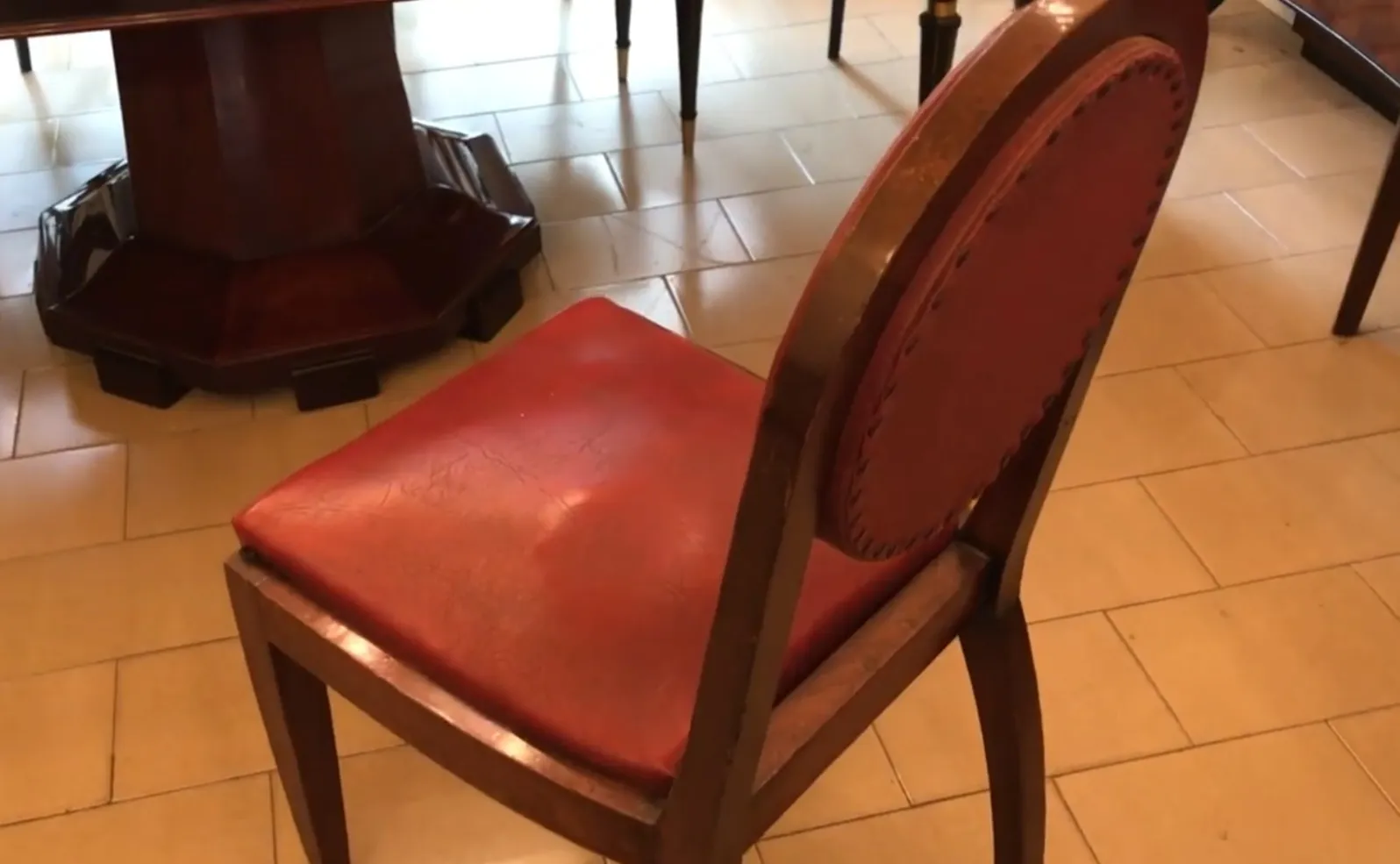 Antique chairs with red upholstery in a decorative setting.
