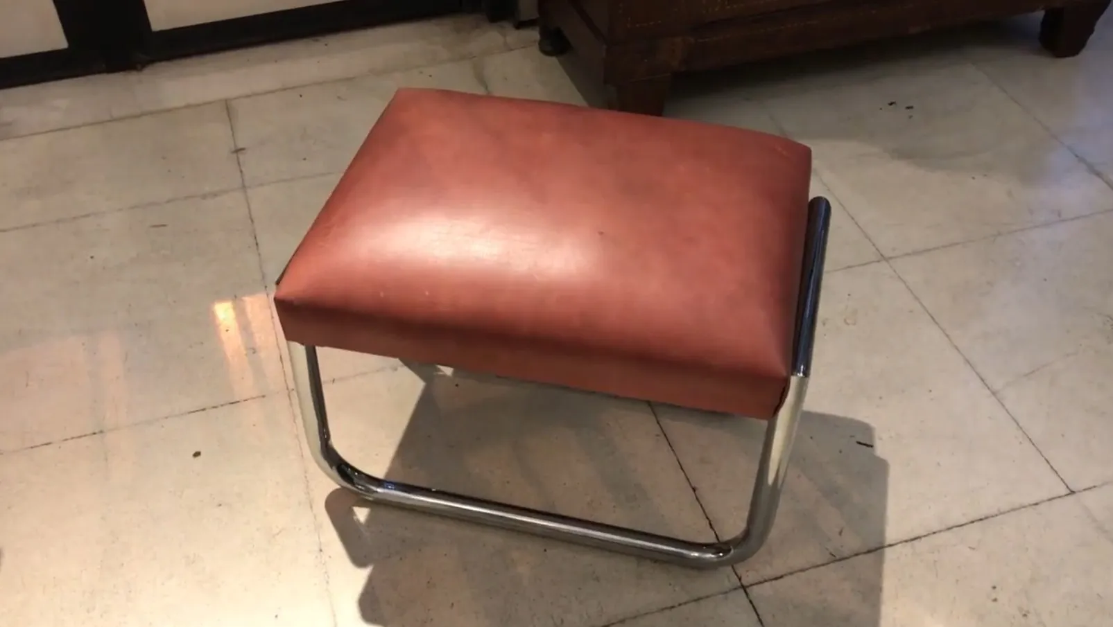 Stool with brown seat, shiny metal frame