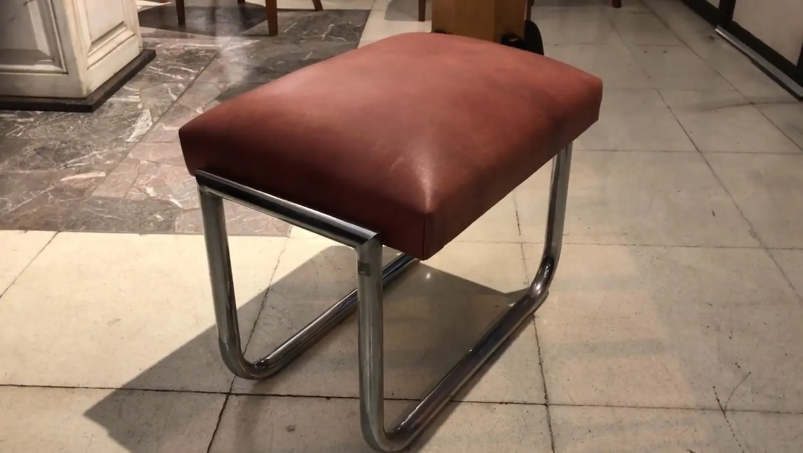 tabouret marron avec assise rembourrée dans un cadre élégant