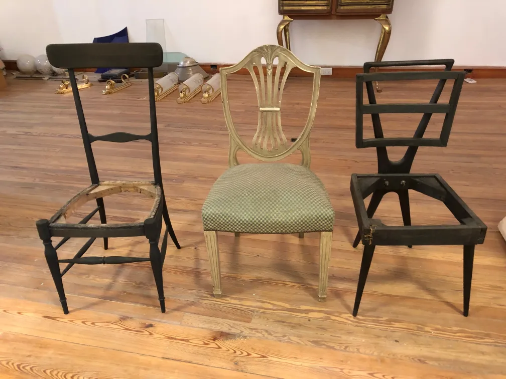 Trois chaises anciennes à restaurer, dans un cadre d'atelier.