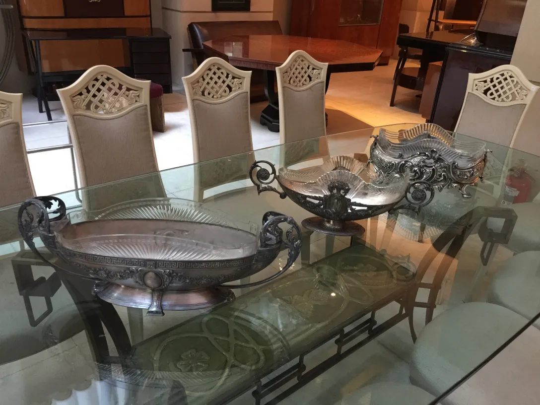 View of 12 antique chairs in an elegant dining room, next to two decorative pieces