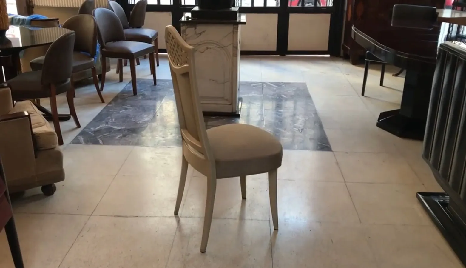 Side view of 12 antique chairs in a well-lit room