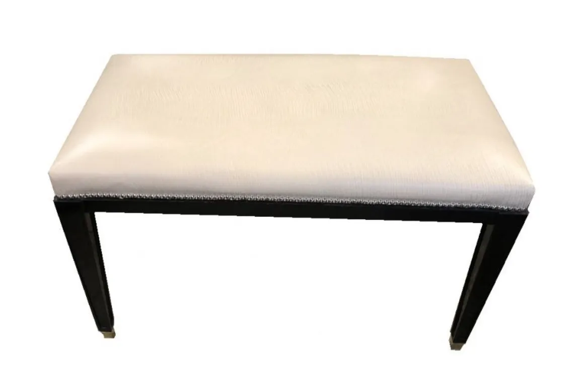 banqueta antigua con diseño clásico y patas negras en un ambiente neutral