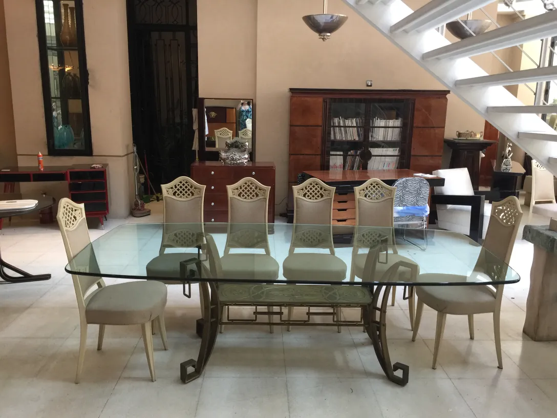 View of 12 antique chairs to restore, arranged around an elegant table in a modern setting