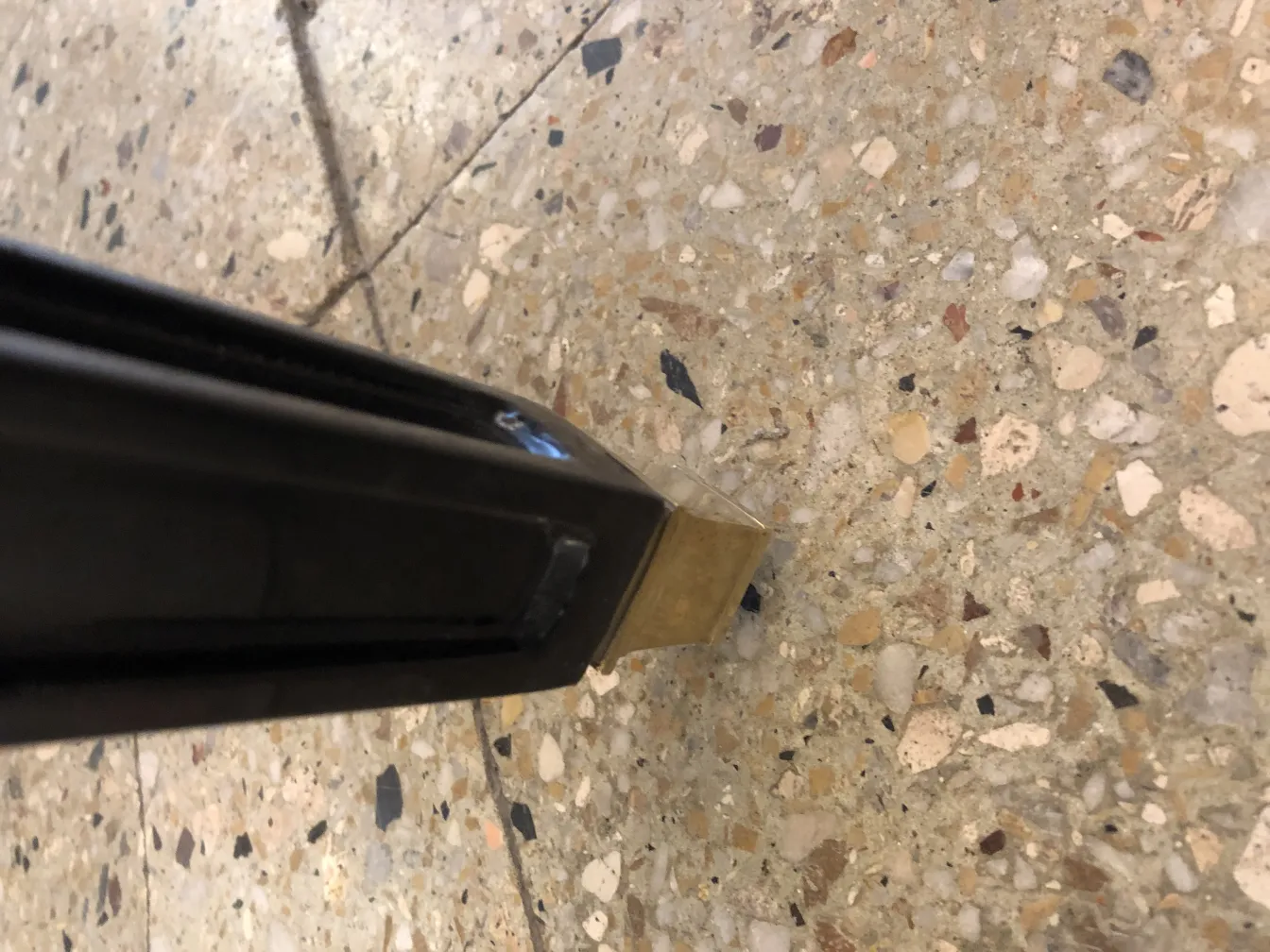 古老的小板凳金属底座，置于石地面上。