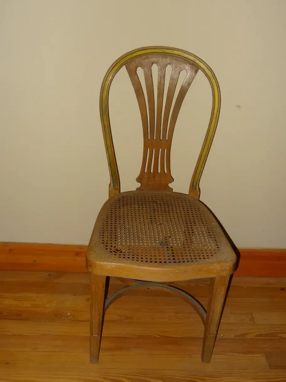 Sedie antiche thonet con intreccio, da restaurare in un ambiente neutro.