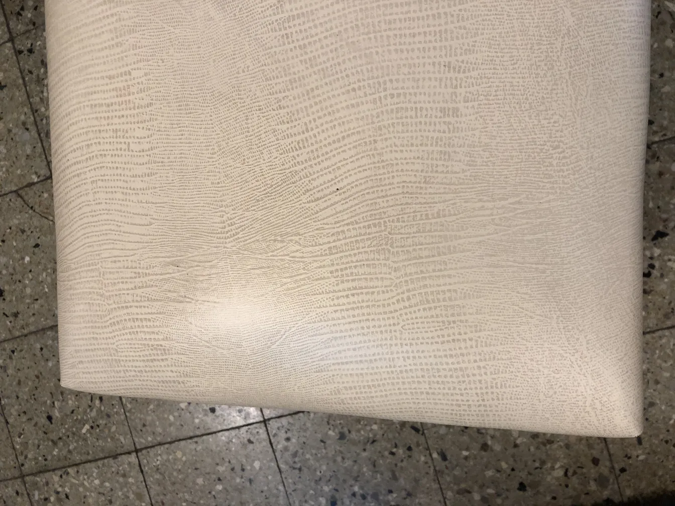 Tabouret antique avec une texture lisse sur sa surface, fond clair.