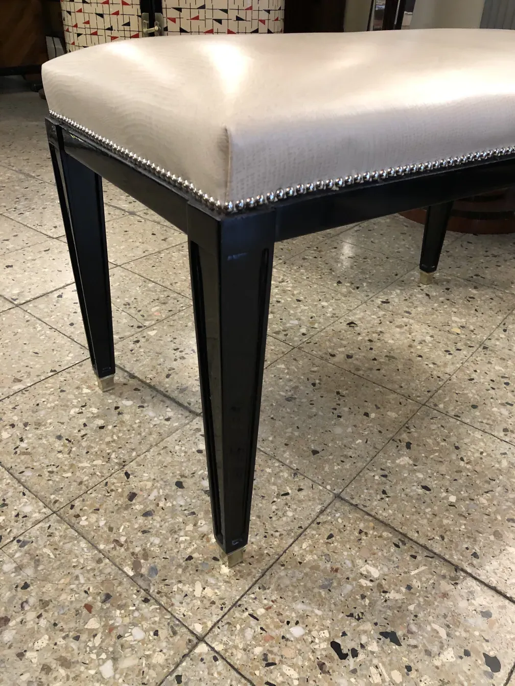 Tabouret ancien avec un siège confortable et bords détaillés.