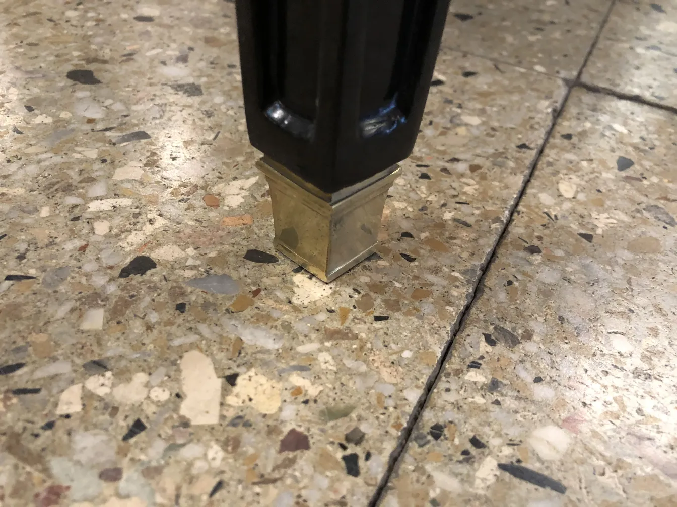 Détail d'un tabouret classique avec une patte en métal brillant.