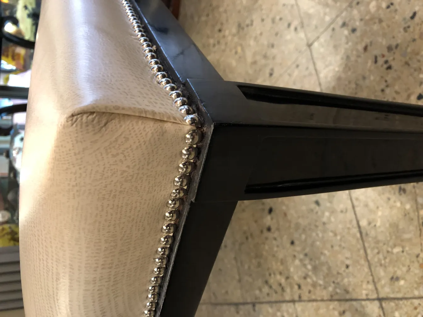 Sgabello antico ed elegante con bordi metallici, in un ambiente accogliente.