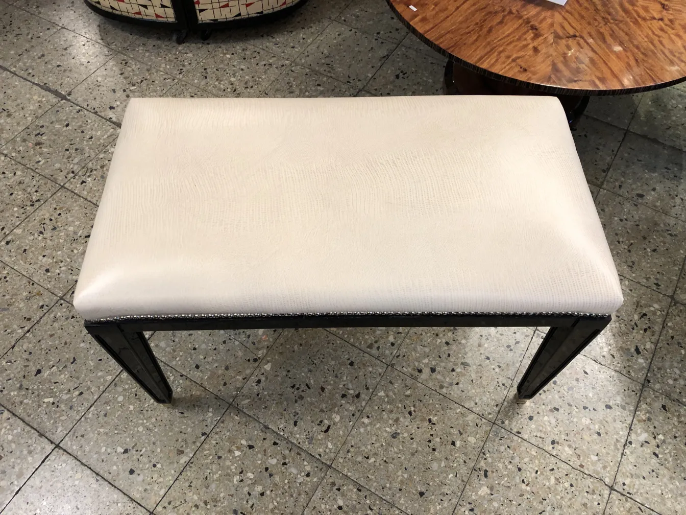 Banqueta clássica com assento branco, ideal para qualquer ambiente.