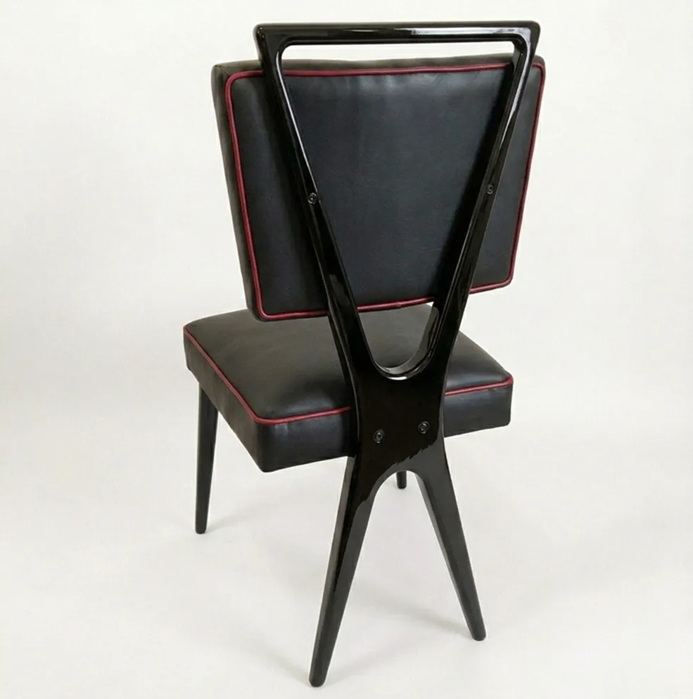 Vista traseira de 12 cadeiras antigas com detalhes vermelhos.