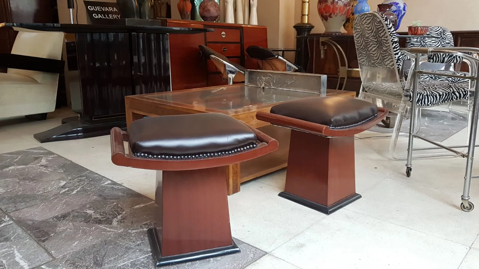 Dos banquetas con cojines oscuros en un ambiente elegante de salón