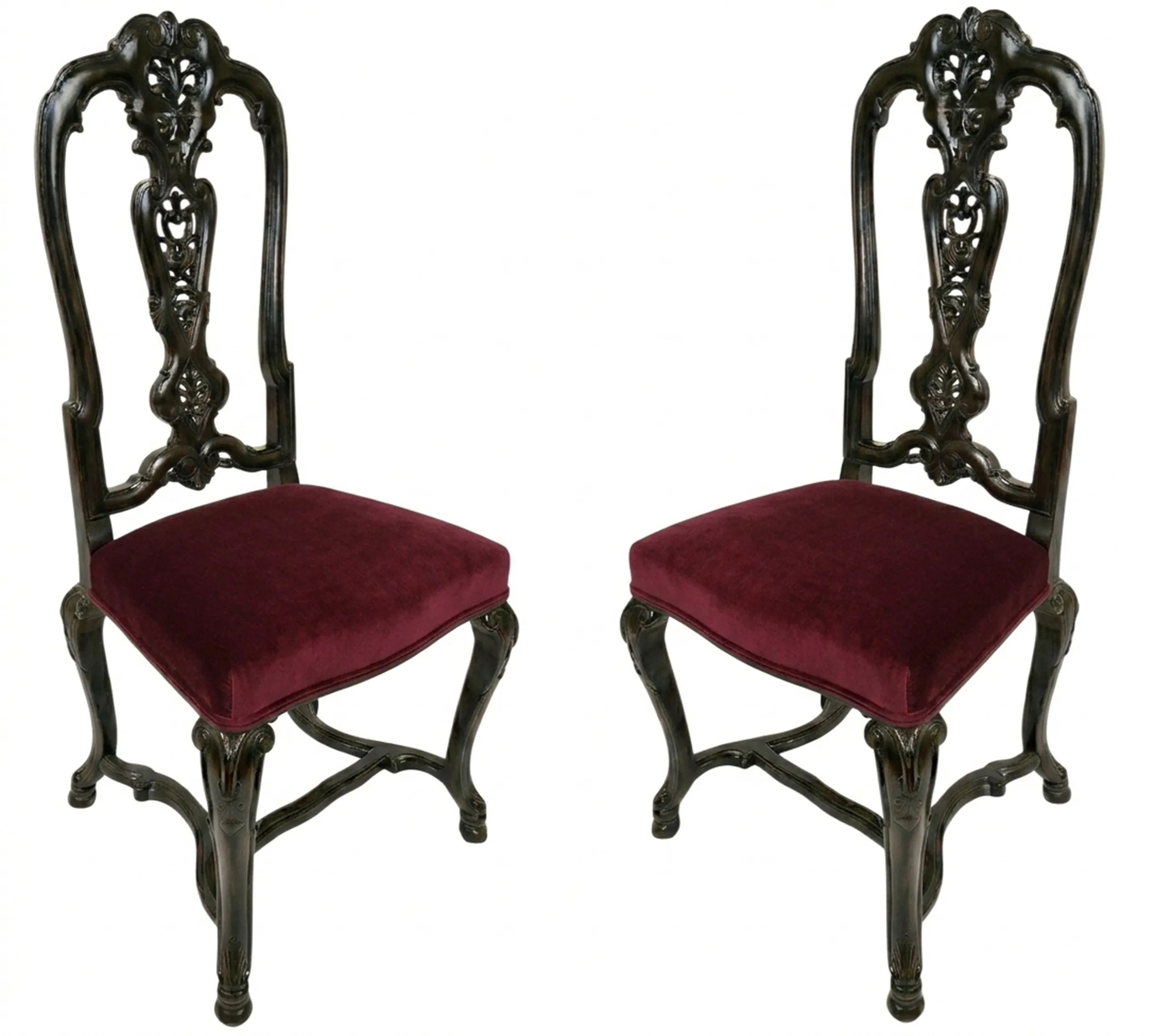 Conjunto de 2 cadeiras antigas com costas esculpidas e almofadas bordô em um ambiente clássico.
