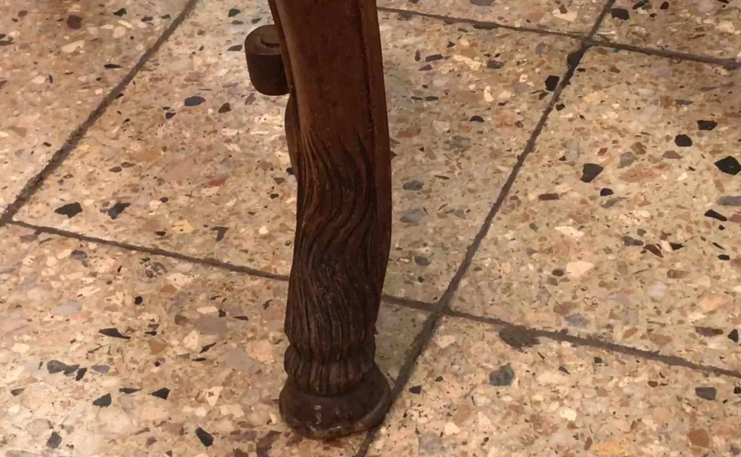 Basis von antiken Stühlen auf einem glänzenden Steinboden.